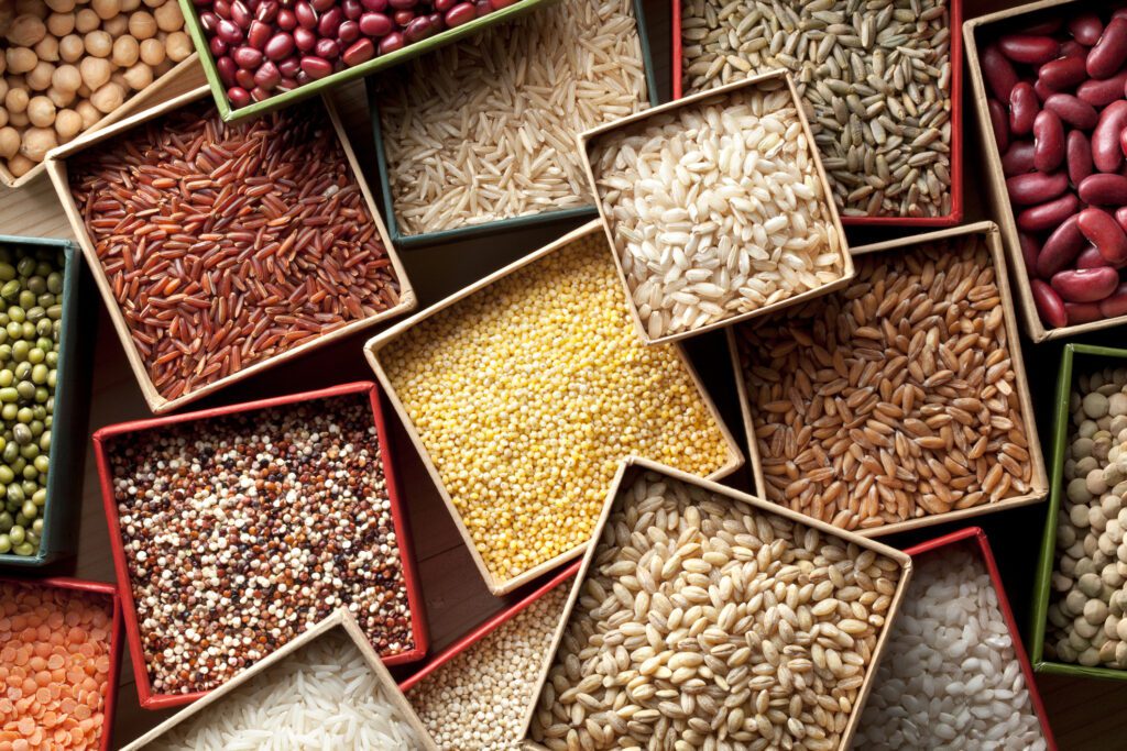tigelas quadradas com diversos grãos e sementes coloridos como arroz, ervilha, quinoa, etc.