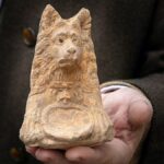 Estátua com cabeça de cachorro encontrada durante escavação em uma estrada romana