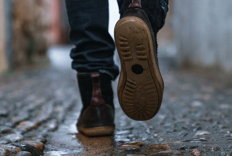 pés com sapatos andando em uma rua de pedras