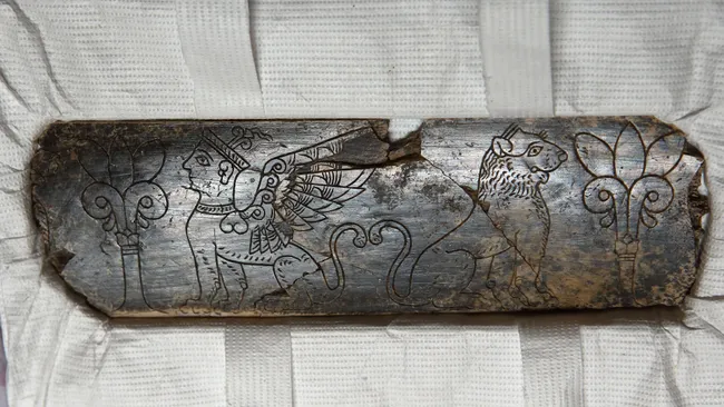 pedaço da presa de um elefante esculpido com animais mitológicos com cerca de 2.800 anos. 