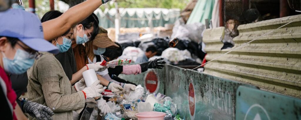 pessoas revirando lixo plástico