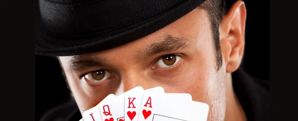 olhos de um homem segurando cartas de baralho