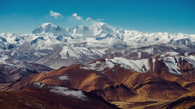 Cordilheira com montanhas cobertas de neve e céu azul