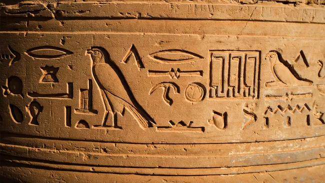 Antigos hieróglifos egípcios esculpidos em arenito no Templo de Kom Ombo em Aswan.