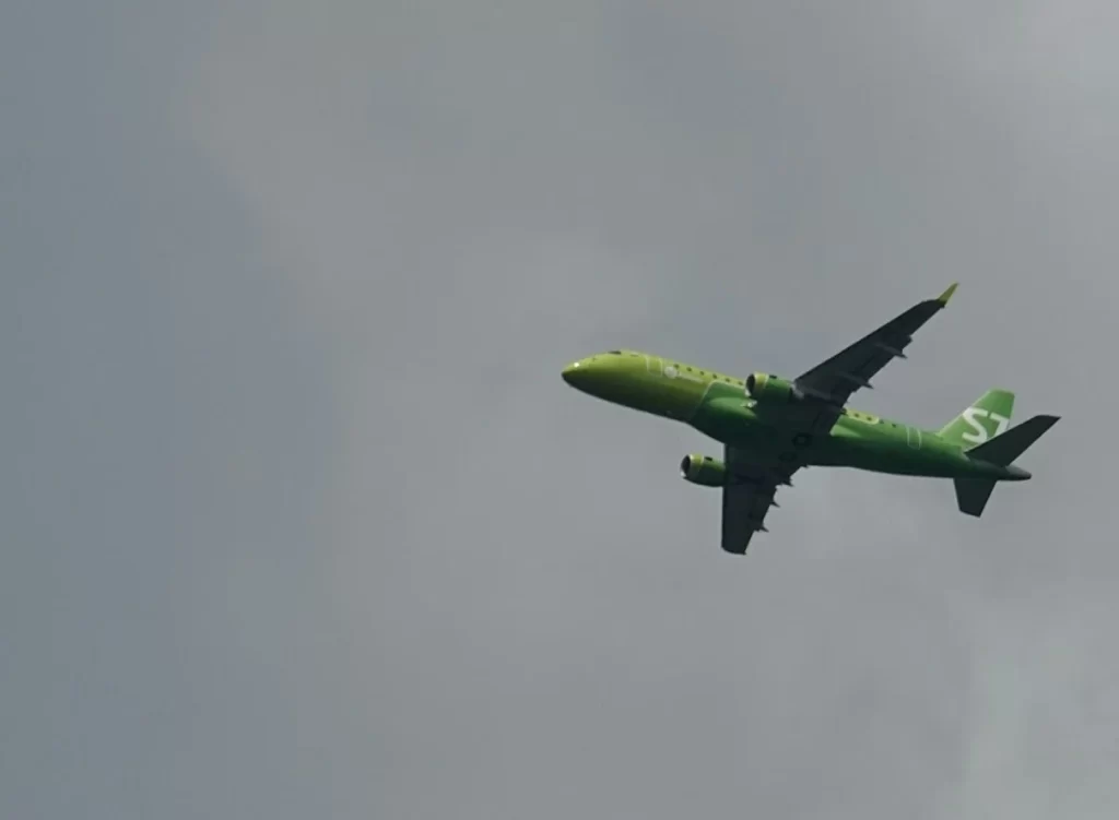 Avião verde com céu cinza ao fundo