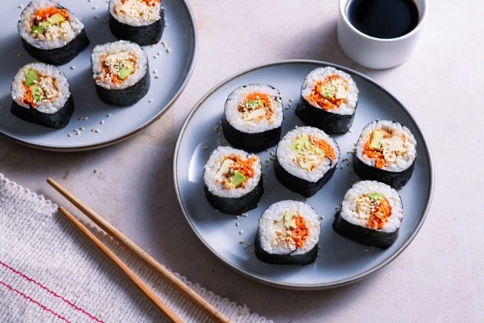 Dois pratos com rolinhos de sushi vegano de tofu e abacate