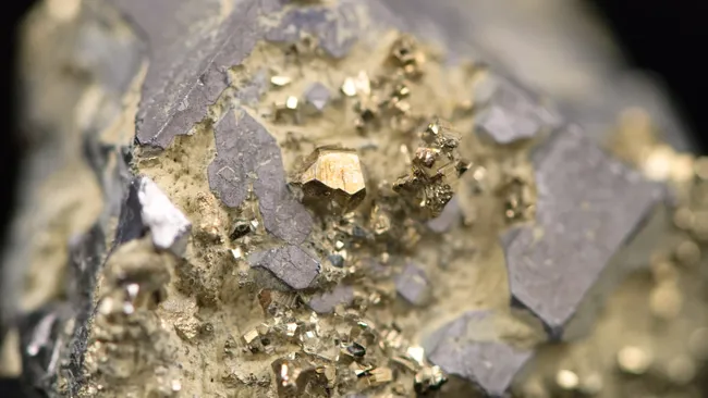 rocha mostrada encontrada em uma mina e contém ouro bruto, que é um mineral de fórmula química Au. 