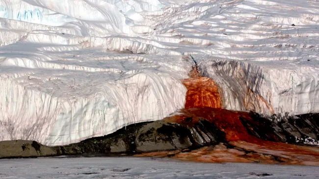 Cachoeira vermelha de ferro no meio de uma geleira na Antártica