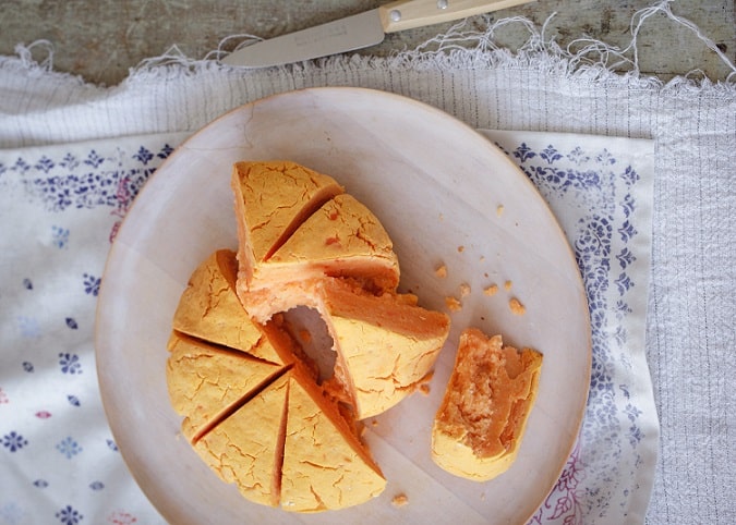 prato visto de cima com pão de batata-doce fatiado com uma faca ao lado