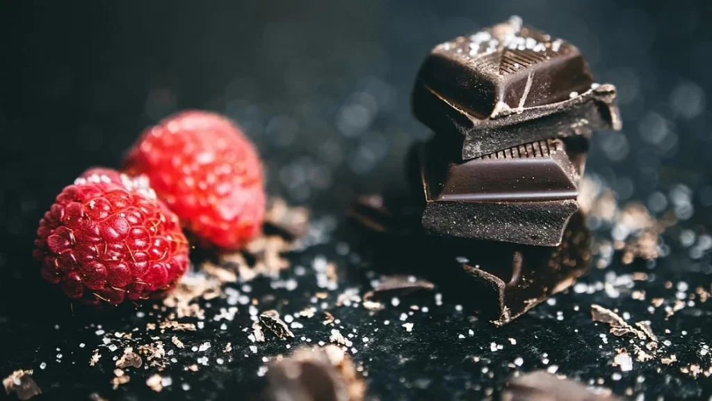close up de amoras e pedaço chocolate amargo