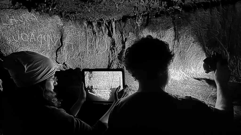 Pesquisadores fotografam as inscrições encontradas na caverna Cova de les Dones, em Valência, Espanha.